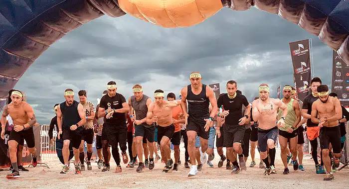 Participants running through rugged desert terrain during the Desert Warrior Challenge, showcasing endurance and camaraderie