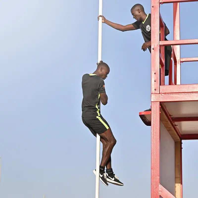 SWAT team member carefully descending a pole during the UAE SWAT Challenge, demonstrating control and tactical skill.